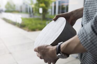 Man holding aluminium billet sample.