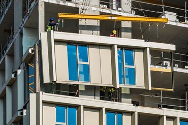 Beige high-rise building with lots of windows in city centre.