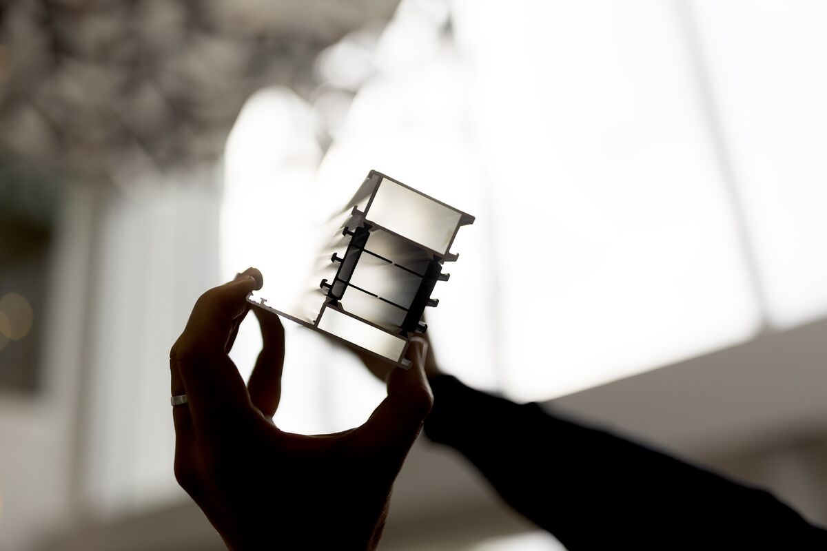 Shadow of insulated aluminium profile, held by two hands.