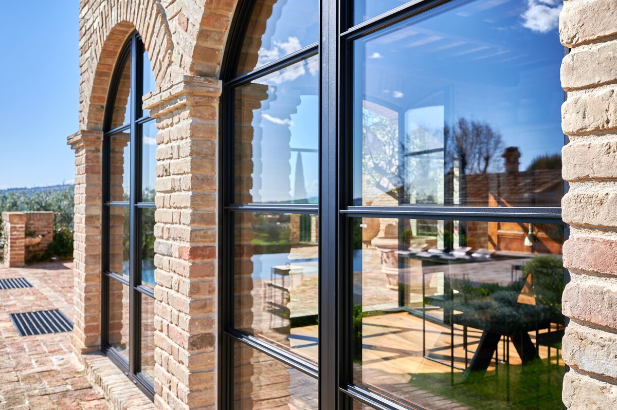 Close up black steel-look windows in brick villa in Italian nature.