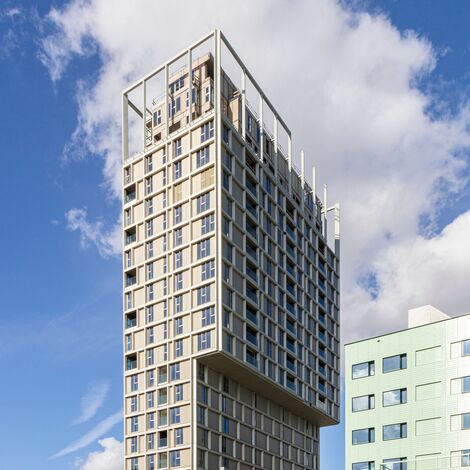 Beige high-rise building with lots of windows in city centre.
