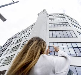 blonde woman in front of white mid-rise building in the city
