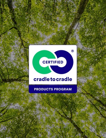 Cradle to Cradle logo in front of green tree tops.