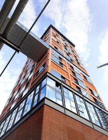 Orange high-rise building looked from below.